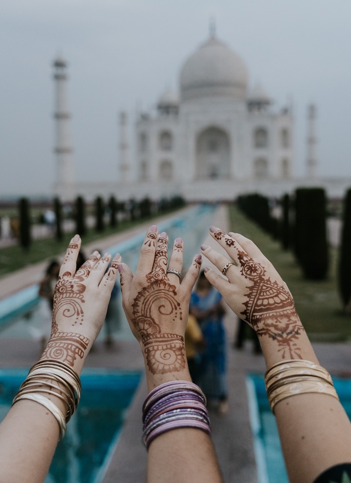 Mãos com henna diante do Taj Mahal
